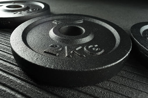 Dumbbell weight plates on a fitness studio / weight training gym floor