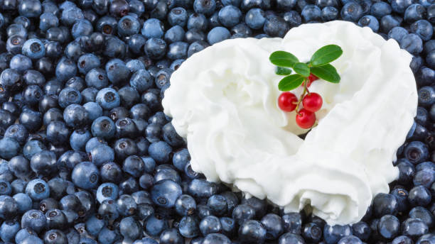 Bilberry texture with cute sweet decoration and twig of fresh cranberries with green leaves