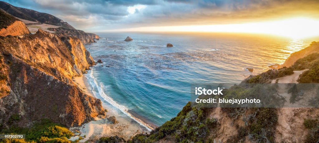 Big Sur coastline panorama at sunset, California, USA Panoramic view of beautiful Big Sur coastal landscape in beautiful golden evening light at sunset with dramatic clouds in summer, California, Monterey County, USA California Stock Photo