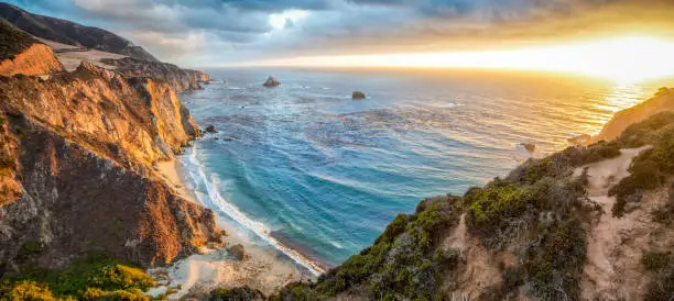 Panoramic view of beautiful Big Sur coastal landscape in beautiful golden evening light at sunset with dramatic clouds in summer, California, Monterey County, USA