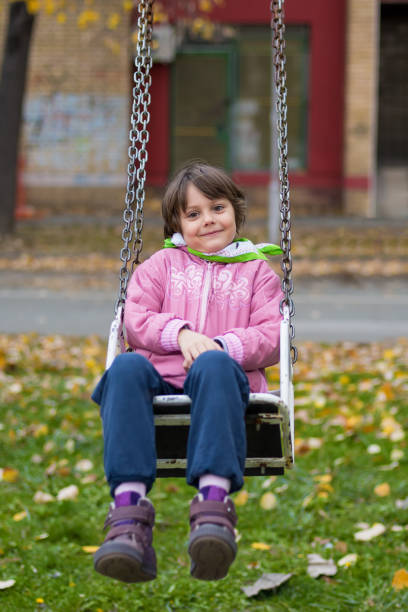 istock Little girl on swing at playground 917304402