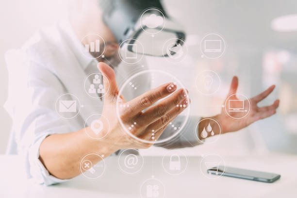 istock businessman wearing virtual reality goggles in modern office with mobile phone using with VR headset with screen icon diagram 917306292