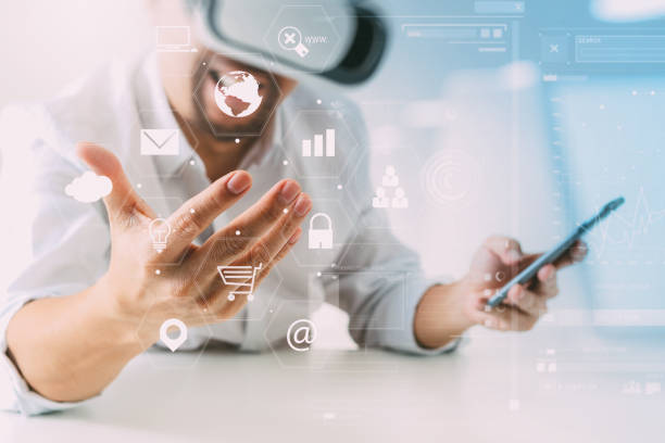 istock businessman wearing virtual reality goggles in modern office with mobile phone using with VR headset with screen icon diagram 917306358