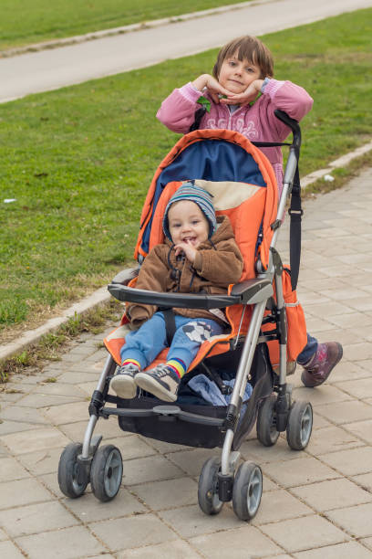 istock sister walking with young brother in stroller 917306506