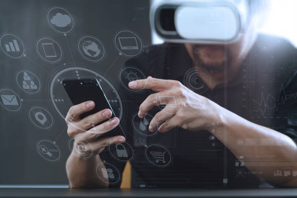 istock businessman wearing virtual reality goggles in modern office with mobile phone using with VR headset with screen icon diagram 917306996