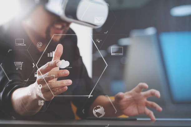 istock businessman wearing virtual reality goggles in modern office with mobile phone using with VR headset 917307034
