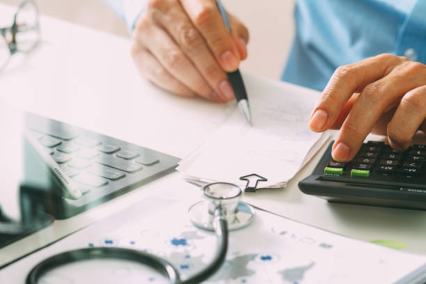 Healthcare costs and fees concept.Hand of smart doctor used a calculator for medical costs in modern hospital stock photo