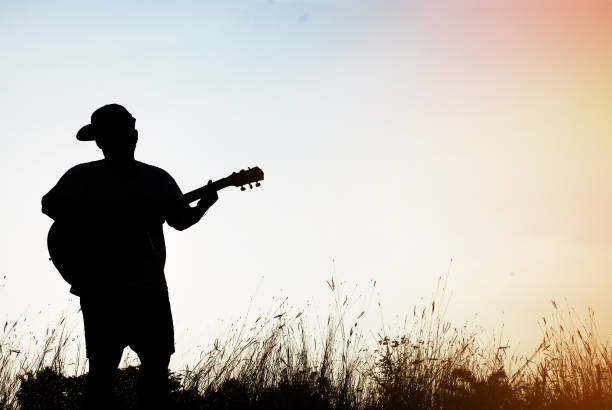 istock Abstract beautiful man playing Guitar the foreground on sky background. 917307498