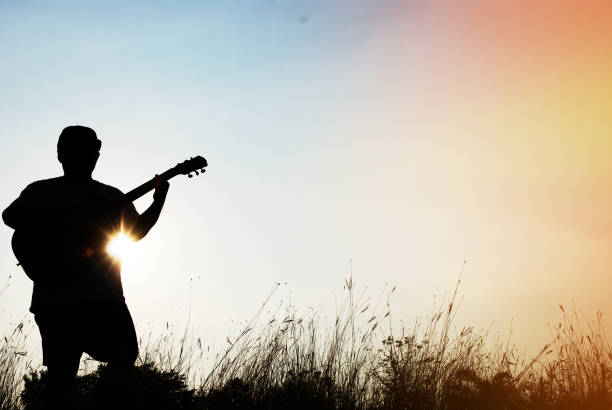 istock Abstract beautiful man playing Guitar the foreground on sky background. 917309872