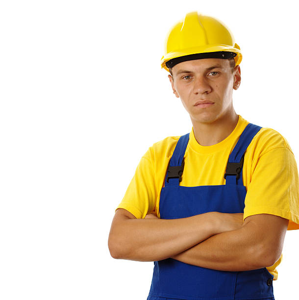 istock Serious young worker wearing hard hat and blue-and-yellow uniform 91731206