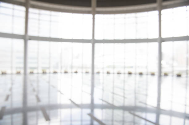 istock Blur background interior view looking out toward to empty office lobby and entrance doors and glass curtain wall 917317400
