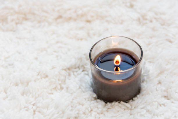 istock Black candle burning on white textured background with room for copy 917325140