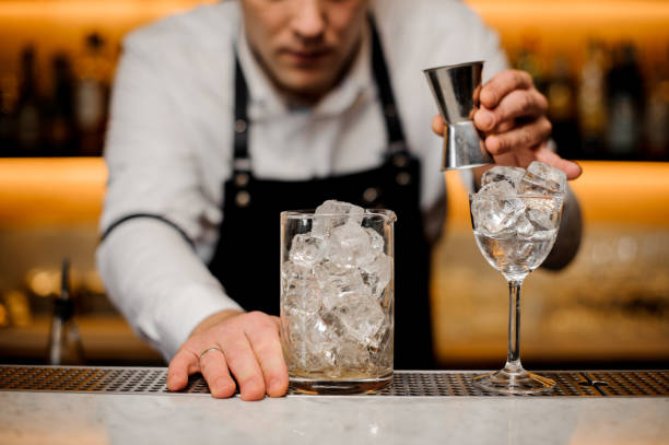 istock Bartender dressed in a white shirt with a glass with ice cubes 917325568