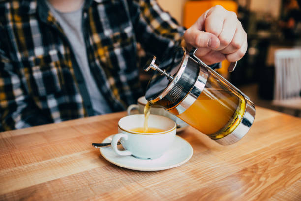 istock man fill up cup with hot tea from french press 917328030