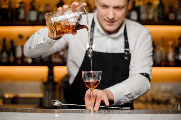 istock Young bartender pouring alcoholic drink into a glass 917328034