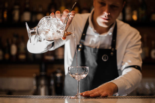 istock Barman adding vodka into a cocktail glass in the dark light 917328934