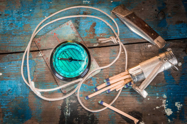 istock Compass, knife, match safe on paint splattered wooden table 917339556