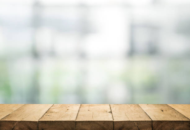 istock Wood table top on blur of abstract window glass 917339740