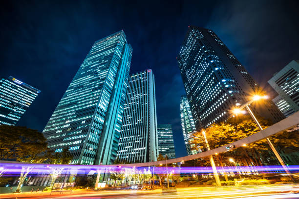 nachtansicht im road-kreuzung von shinjuku nachschlagen, reflektieren die silhouetten der wolkenkratzer dämmerung himmel in tokio, japan - shinjuku bezirk stock-fotos und bilder