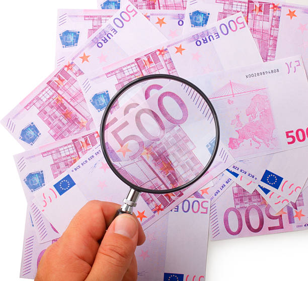 istock Hand holding magnifying glass over money - Euros 91734353