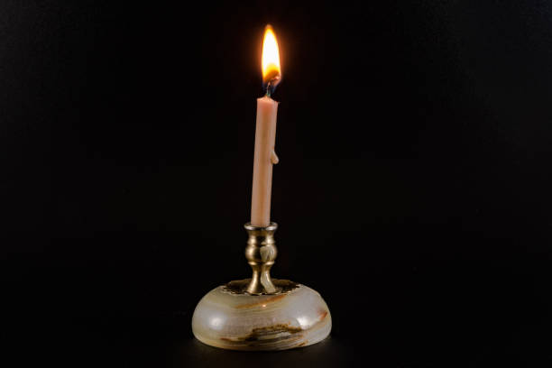 istock Burning candle on a stand on a black background 917344178