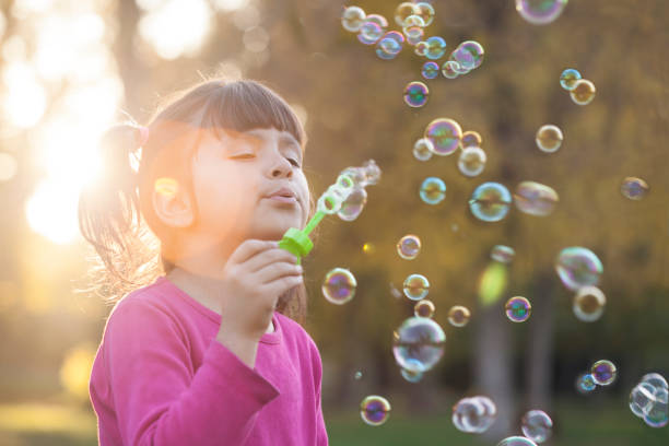 istock little girl is blowing a soap bubbles 917360888