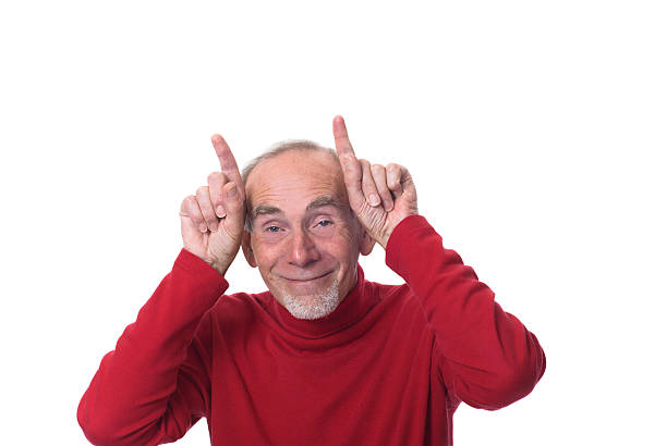 Funny old man making devil horns stock photo