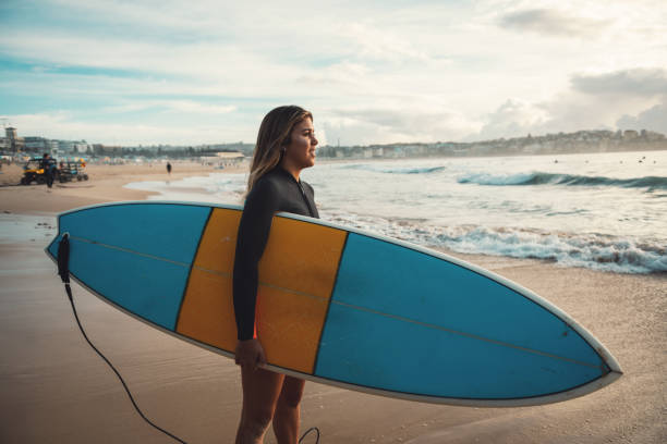 istock Woman surfer jumps on her surfboard in the wave 917375692