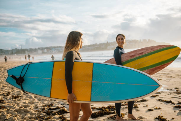 istock Two young women putting on wet suits for surfing 917375696