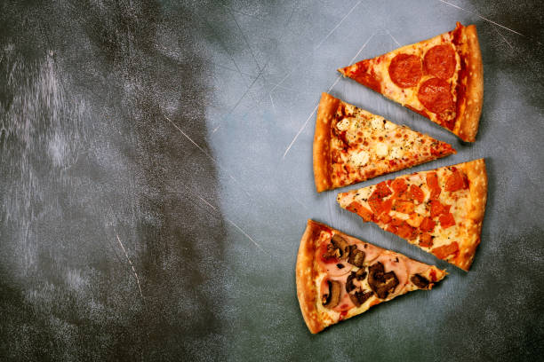 istock Slices of pizza with different fillings on a dark textured background 917379588