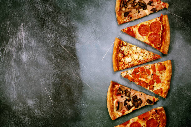 rebanadas de pizza con diferentes rellenos sobre un fondo oscuro con textura - comida para llevar fotos fotografías e imágenes de stock