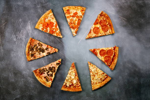 istock Slices of pizza with different fillings on a dark textured background 917379650