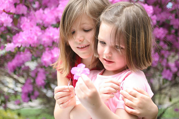 fraternal twin sisters playing soft ball outdoors
