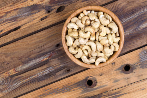 生カシュークローズアップの木製のボウル - cashew close up food salted ストックフォトと画像