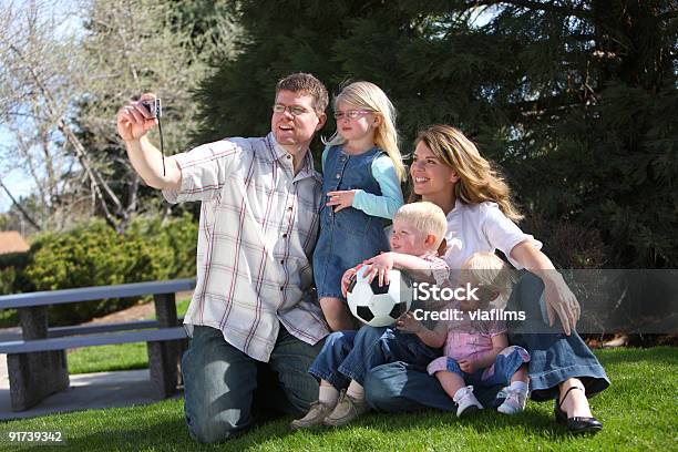 Familia Tomando Un Autorretrato En Park Foto de stock y más banco de imágenes de 12-23 meses - 12-23 meses, Adulto, Aire libre