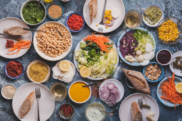 フラットのダイニング テーブルで食事を置くビーガン野菜デトックス ダイエット食品のコンセプト - 副菜 ストックフォトと画像