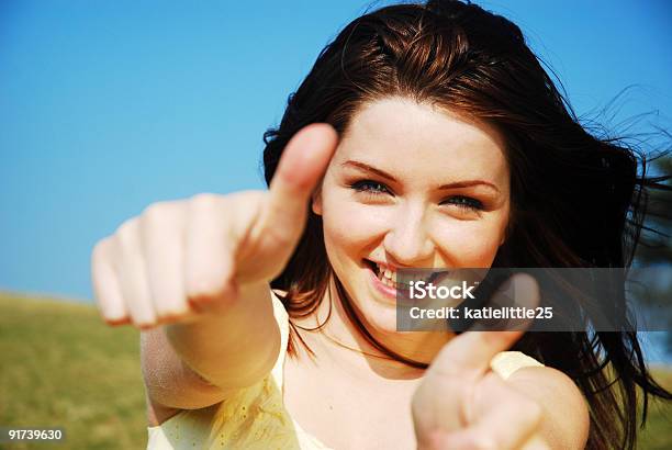 Young Woman Giving Two Thumbs Up Stock Photo - Download Image Now - One Woman Only, Sky, Smiling