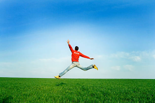 Man Jumping at meadow stock photo