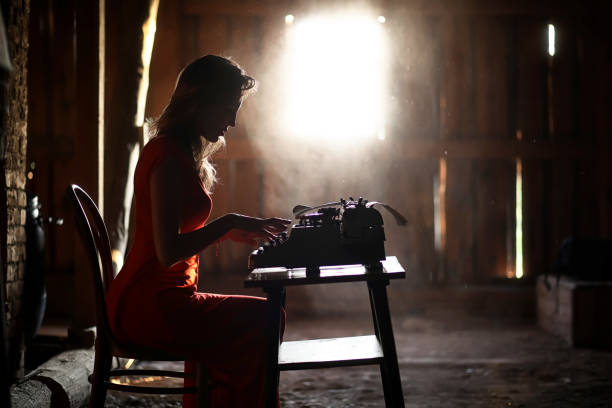 A girl in retro style prints on an old typewriter