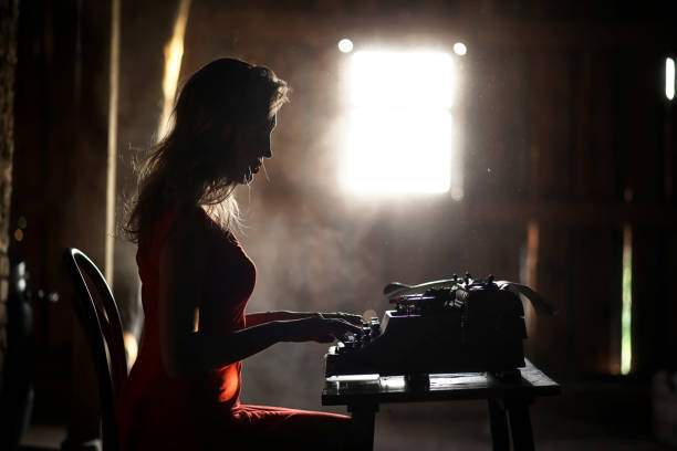 istock A girl in retro style prints on an old typewriter 917403710