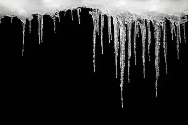 Photo of Icicles on a black background, space for text, template for design