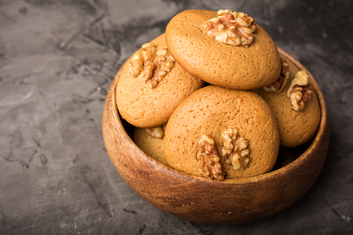 Honey biscuits with walnuts in a wooden bowl. Dark background. homemade food 1