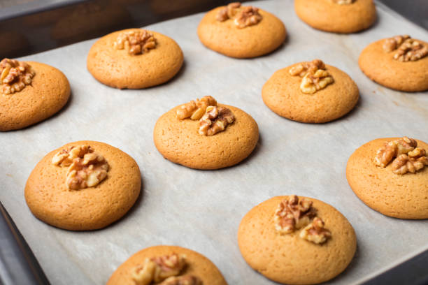 Honey biscuits with walnuts in oven on a baking sheet with parchment paper, ready for baking. home cooking 2