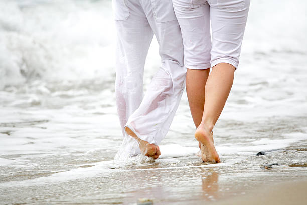 istock A couple clad in white garments take a romantic summer walk 91741619