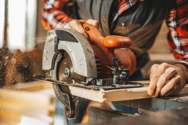 Carpenter cutting plank by circular saw Carpenter cutting plank by circular saw in him workshop sawing photos stock pictures, royalty-free photos & images