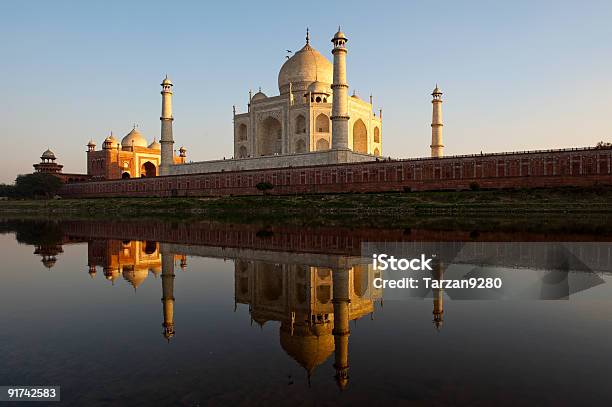 Taj Mahal Y Su Reflejo En Río Yamuna Foto de stock y más banco de imágenes de Puesta de sol - Puesta de sol, Reflejo - Efecto de luz, Taj Mahal