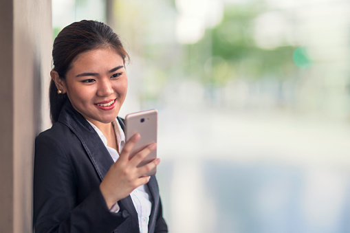 A young businesswoman using her smart phone outdoors.