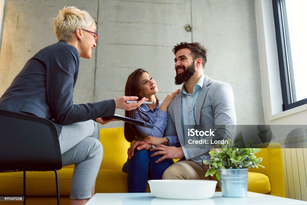 Young married couple at their counselor young married couple with real estate agent, financial advisor or marriage counselor 30-39 Years Stock Photo