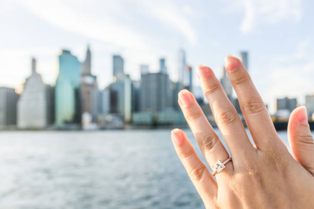 piquées-main de la jeune femme avec la princesse de bague de fiançailles diamant, or dehors en plein air dans new york new york city brooklyn bridge park par east river, cityscape, skyline bokeh - brooklyn bridge bridge brooklyn stone photos et images de collection