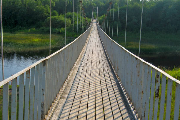Old abandoned suspension bridge over the river